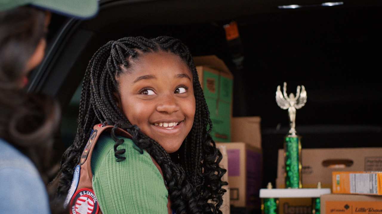a girl smiling in front of a trophy